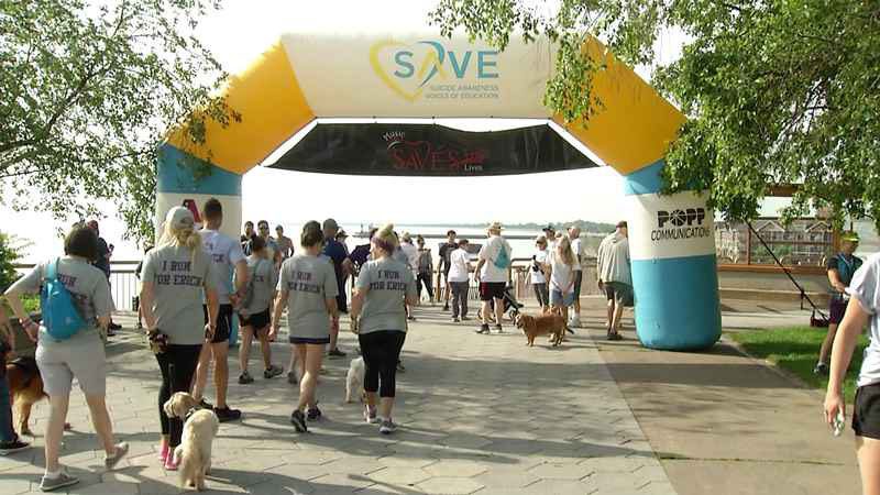 Participants, some with dogs, walk along the lakeshore in Duluth for the 5k Walk/Run for Mental Health