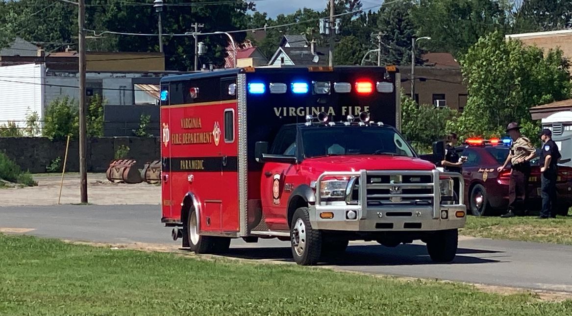 A Virginia ambulance is parked near a baseball field