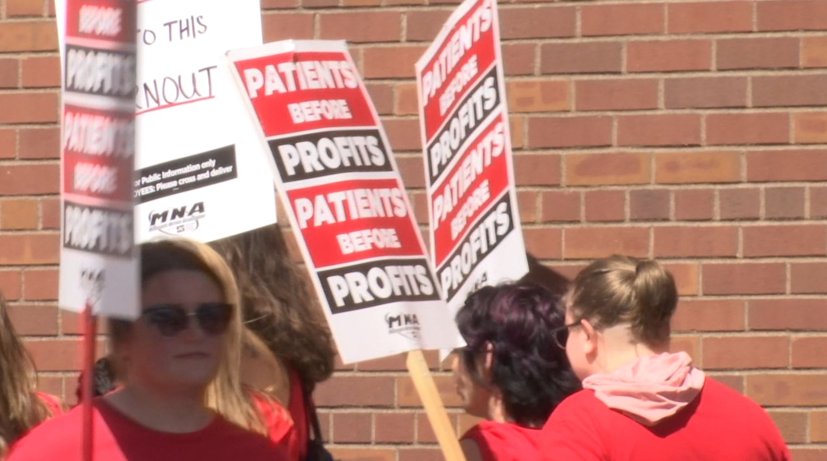 Twin Ports nurses picketing with signs that read "Patients Before Profits."
