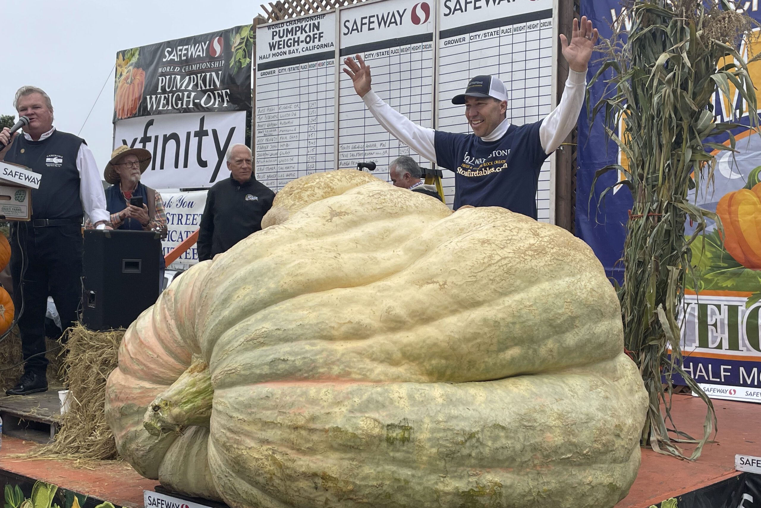 Horticulture teacher stands behind giant pumpkin