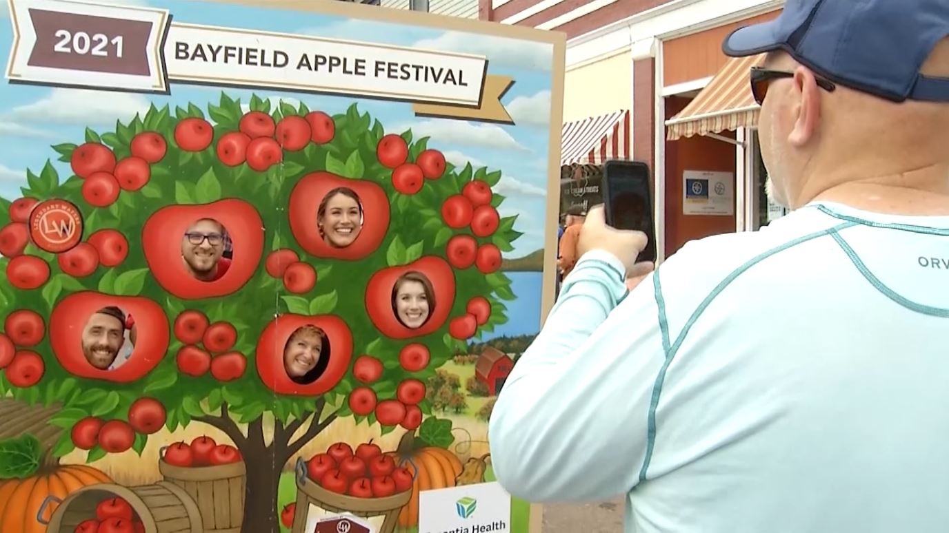 People take a photo in an apple tree cutout