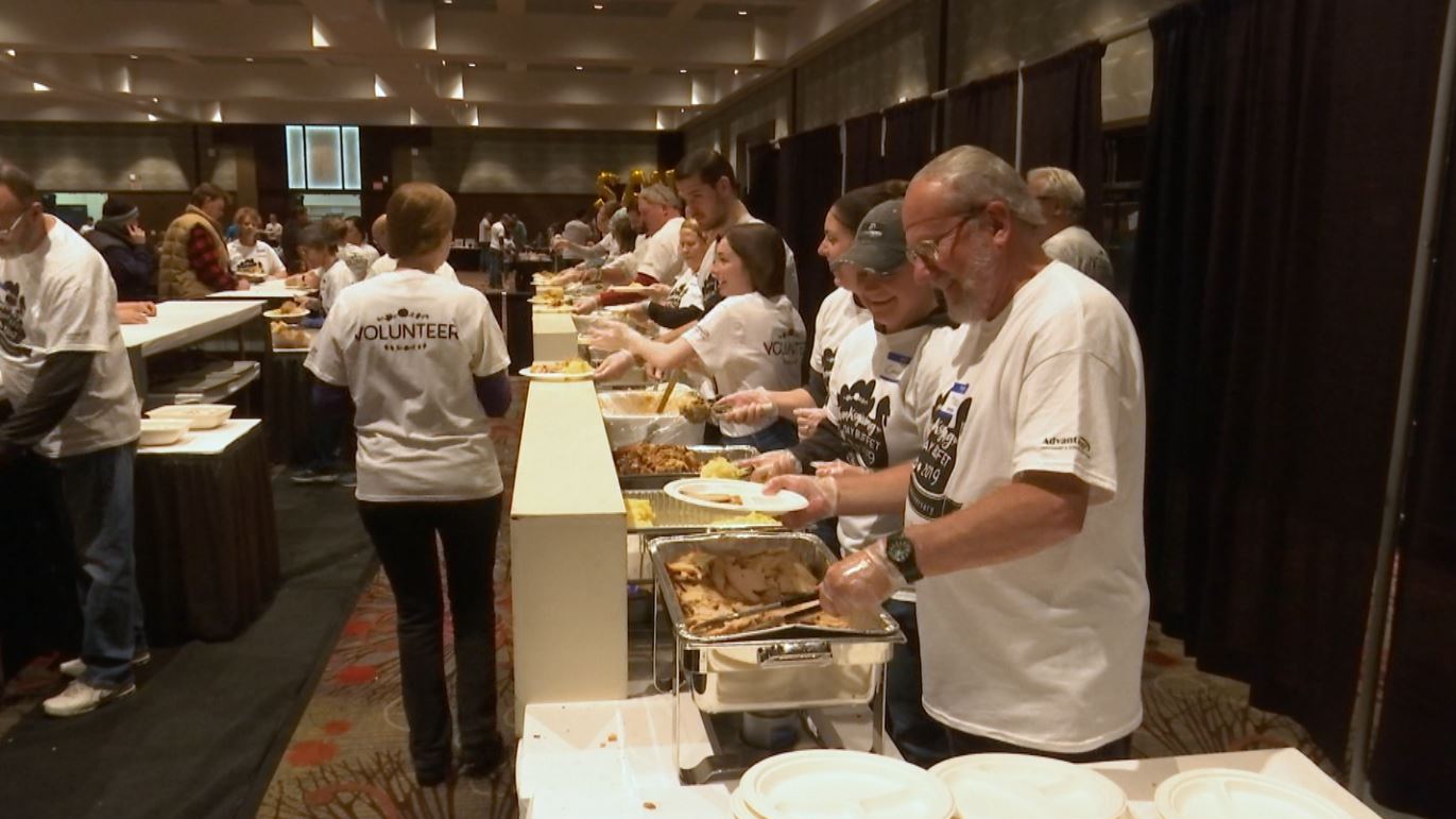 People dish up food in a Thanksgiving buffet line