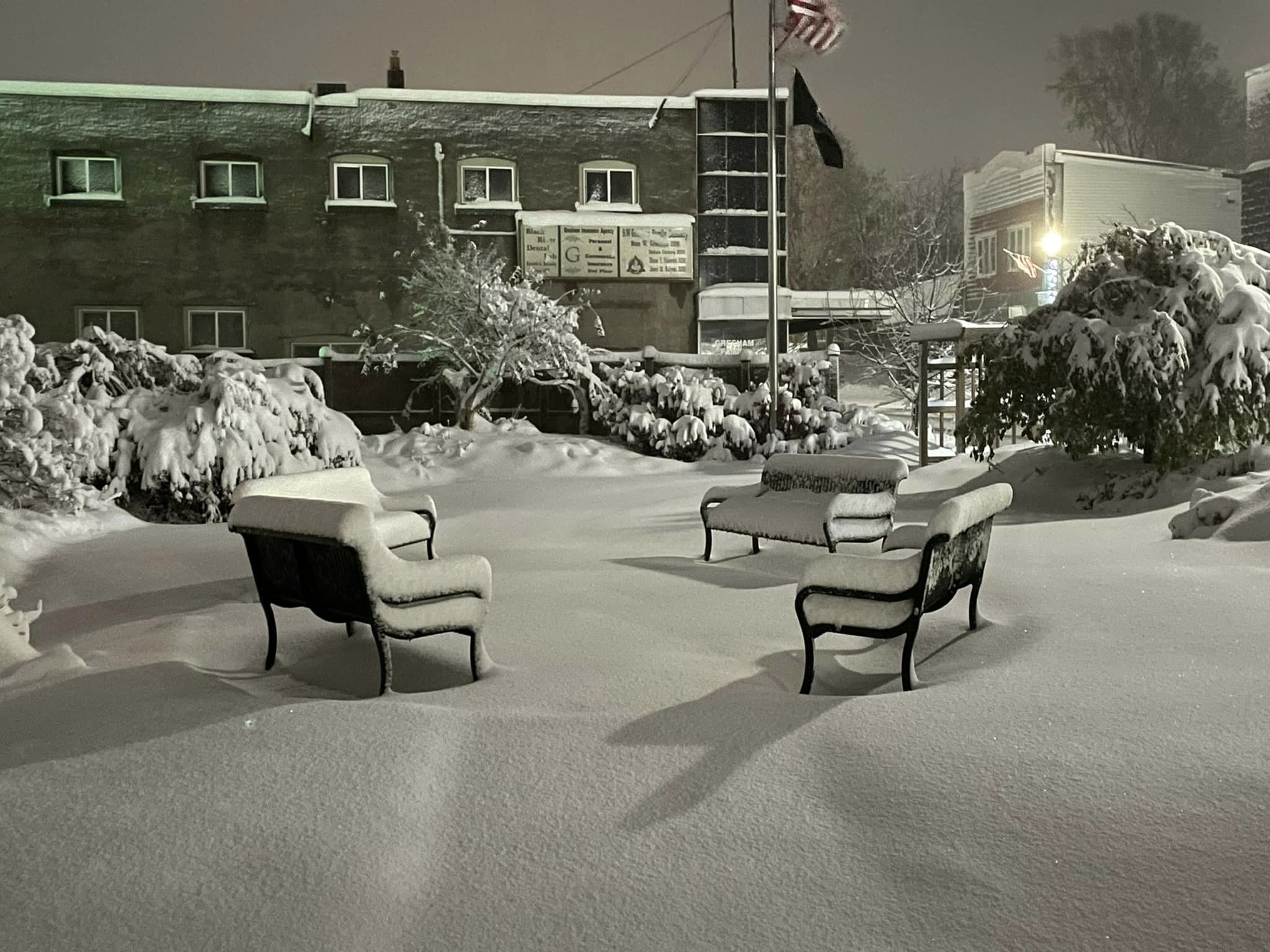 A courtyard with benches covered in snow