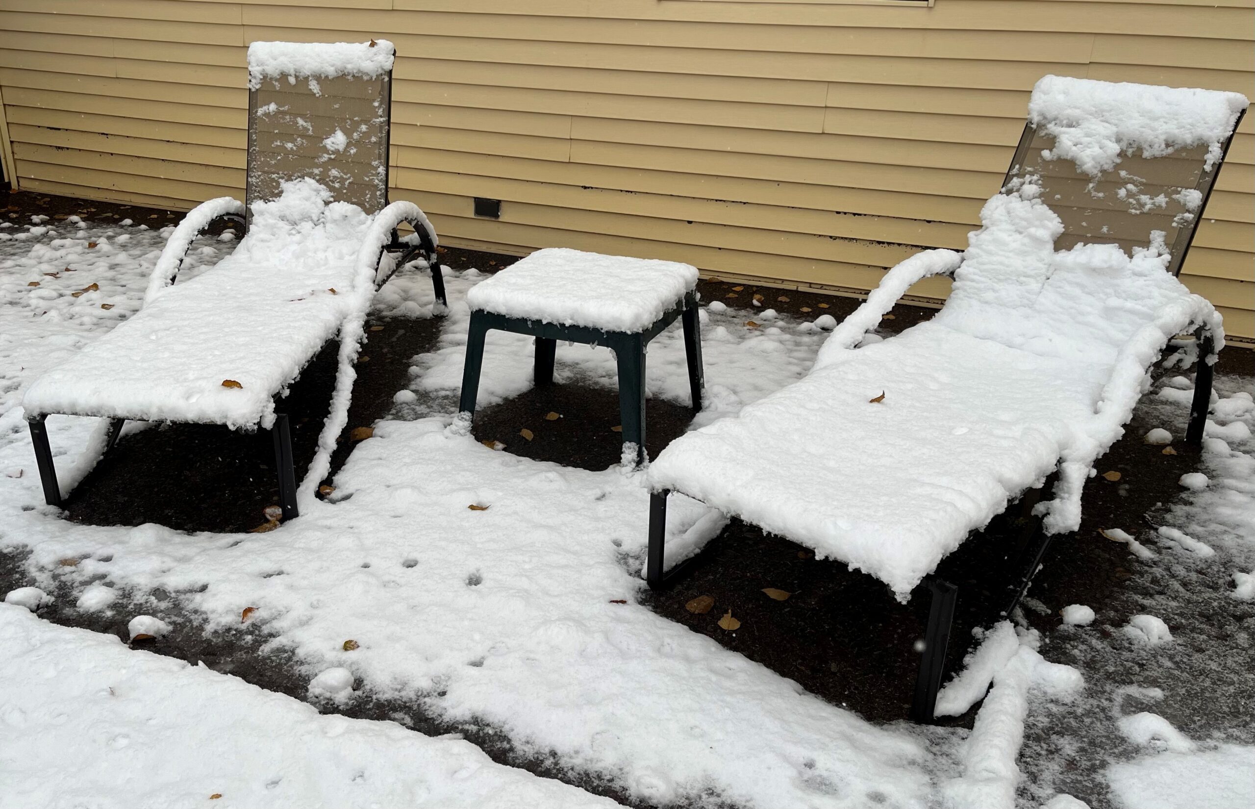 picture of two lounge chairs covered in snow