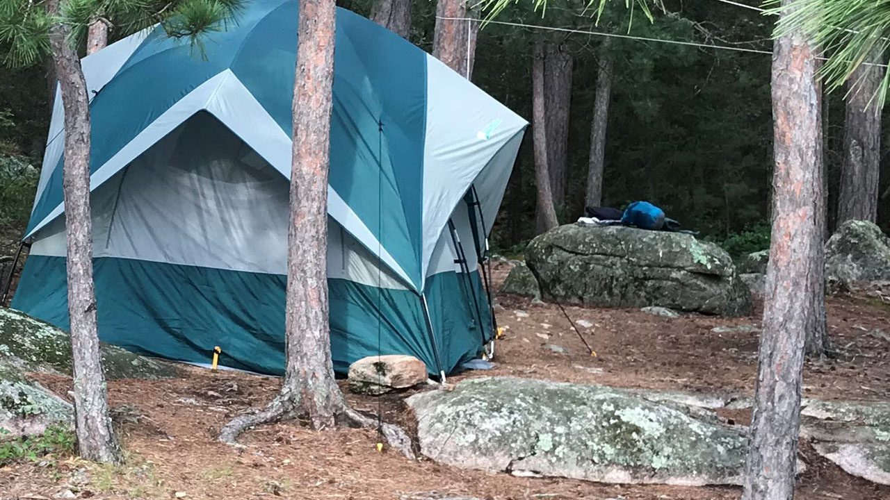 a green tent on a campsite in the woods