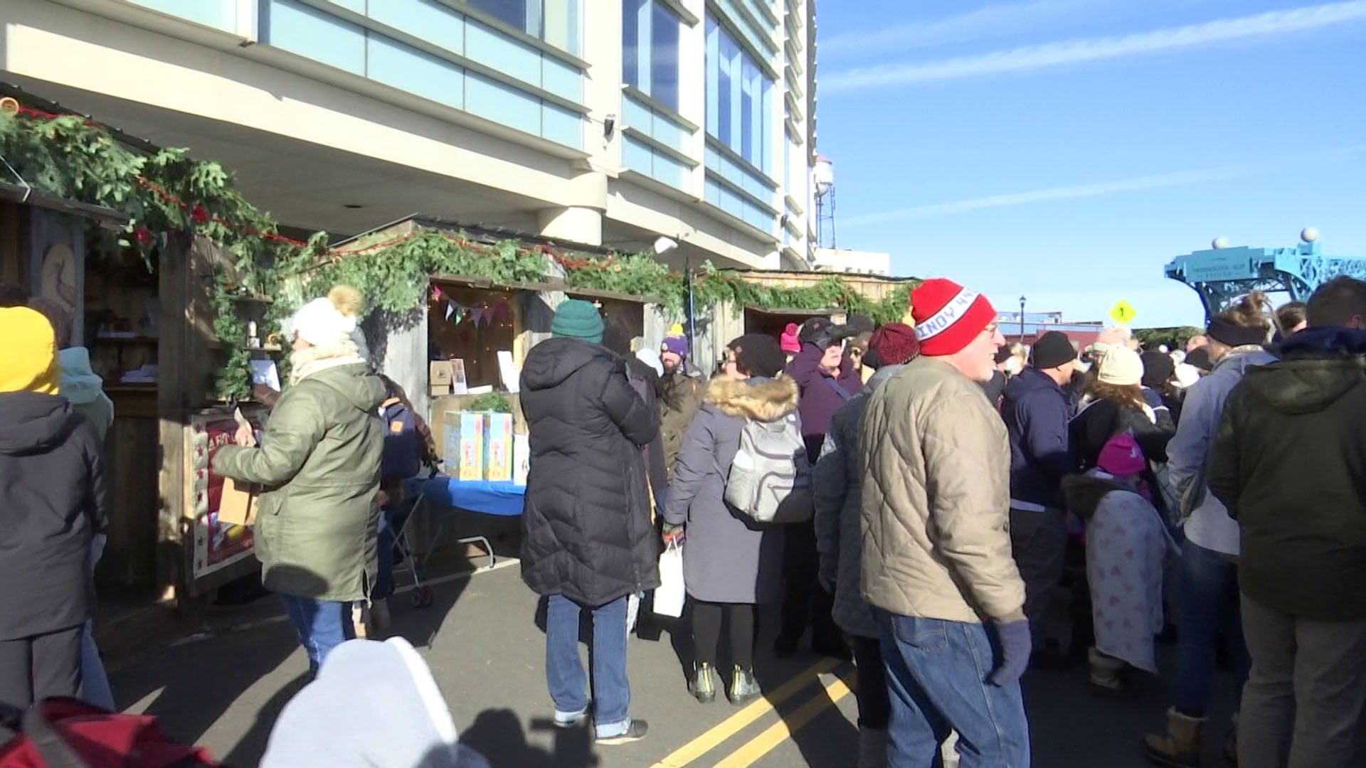 Two festive huts with people shopping the Duluth Winter Village