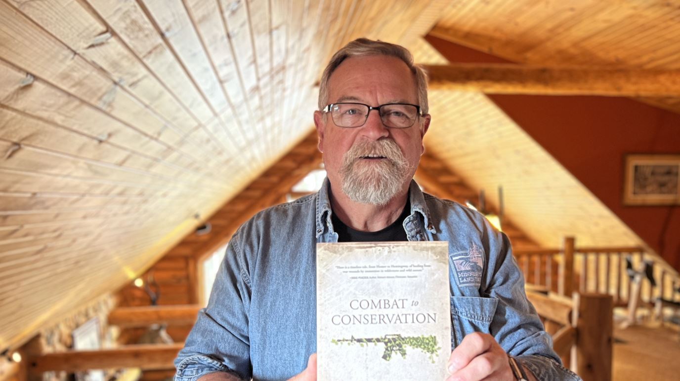 Fitz Fitzgerald holds his book, "Combat to Conservation"