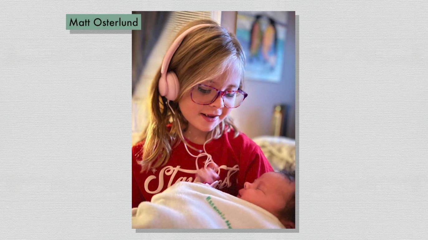 A girl holds her newborn baby sister
