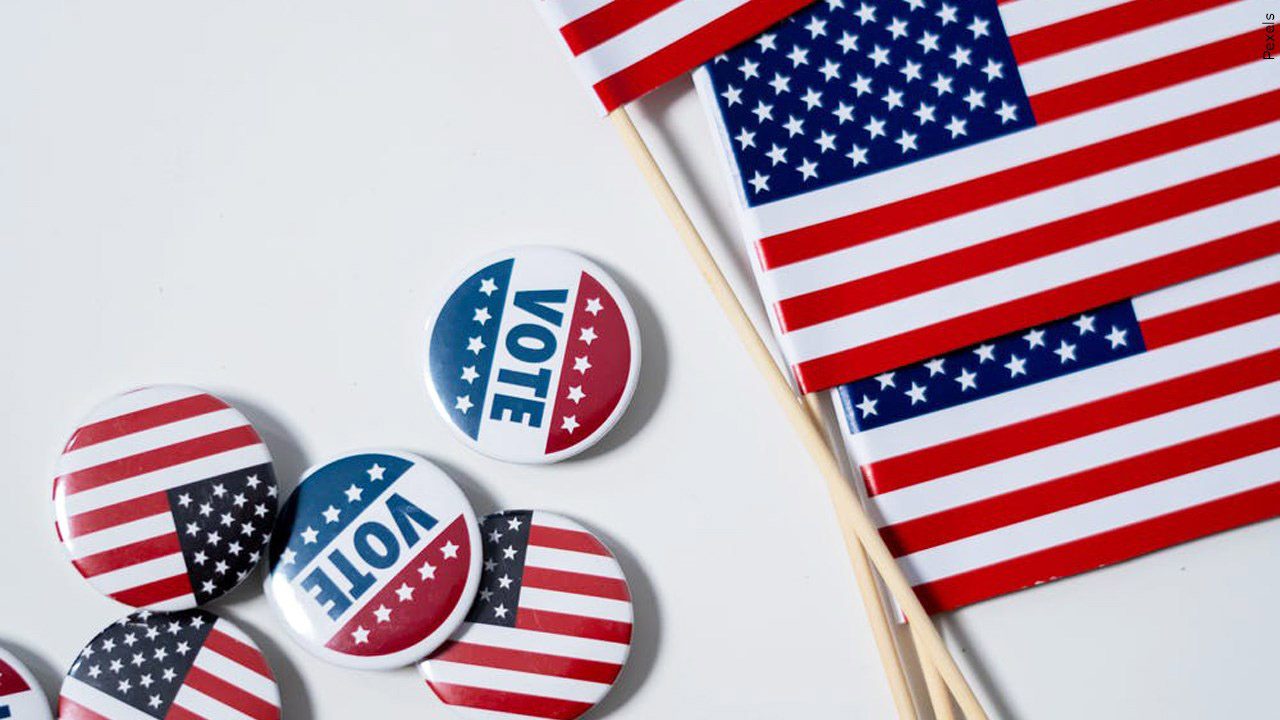 Flags and voting pins over white