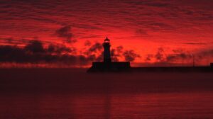 A red sky behind a lighthouse