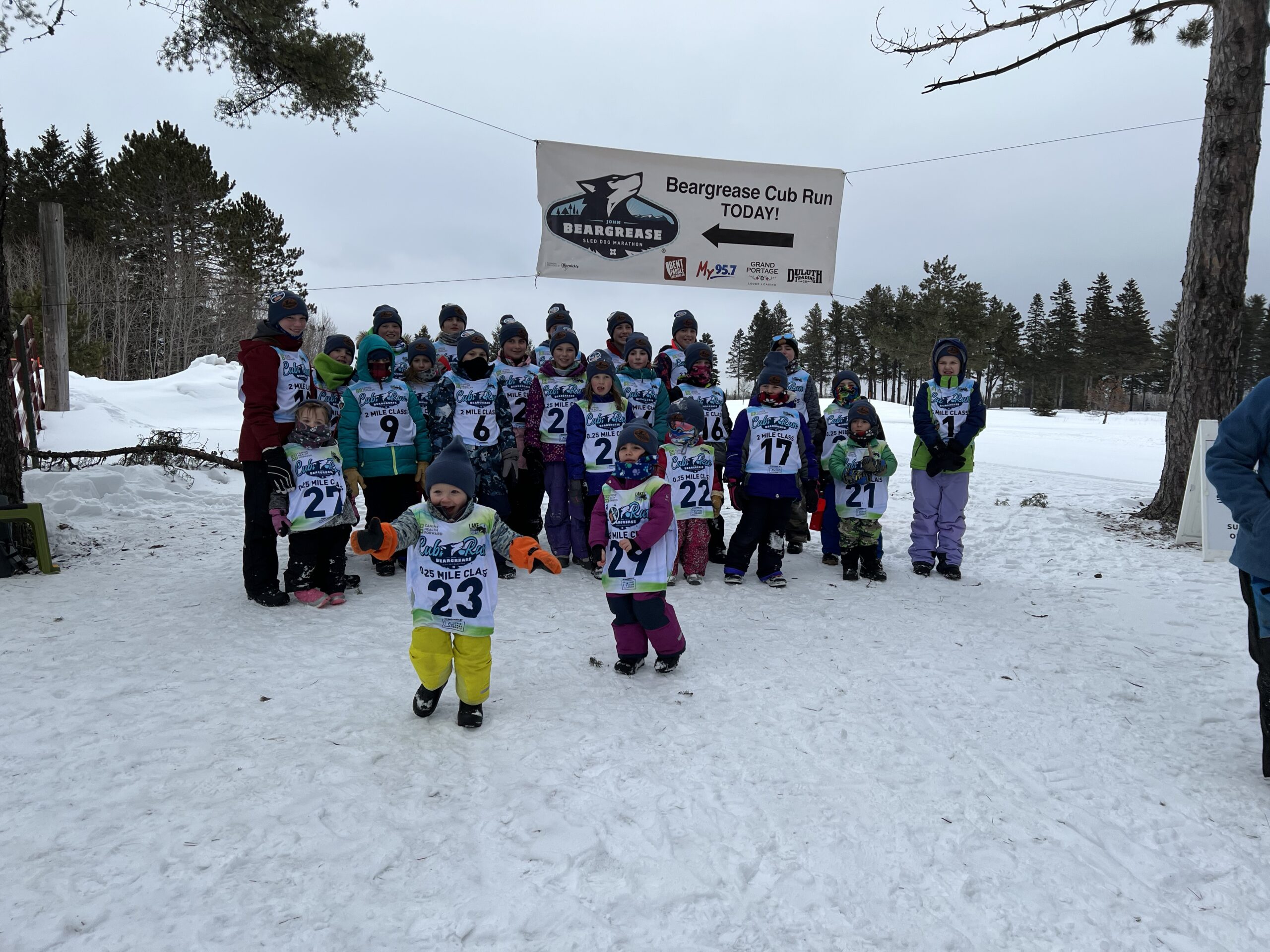 Over twenty kids and young adults pose for a picture at the 2023 Cub Run Sled Dog marathon.