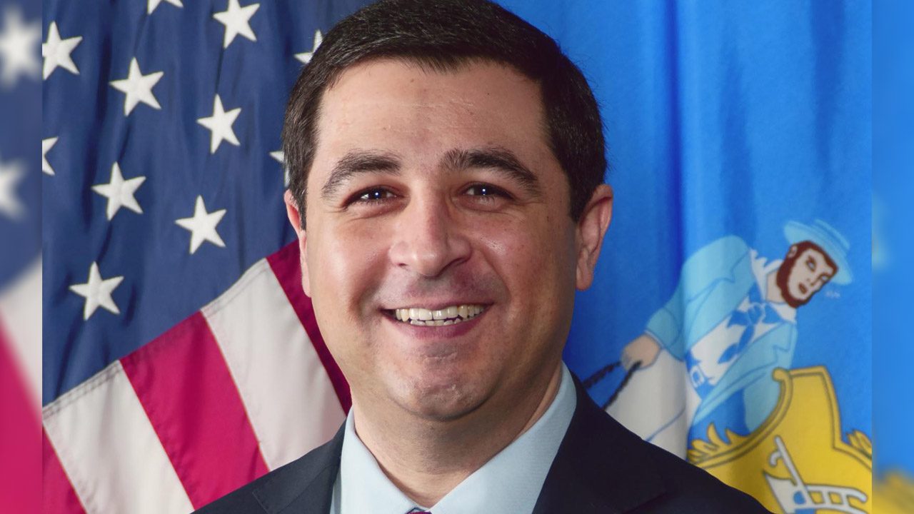 Picture of Josh Kaul in front of U.S. Flag and Wisconsin flag.