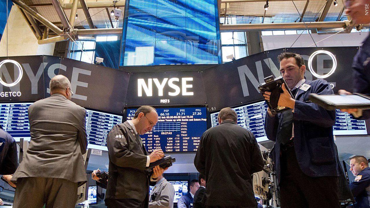 Picture inside the New York Stock Exchange, Men standing with monitors.