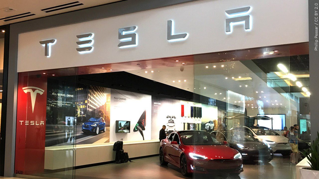 looking into a Tesla showroom with a red car in front.