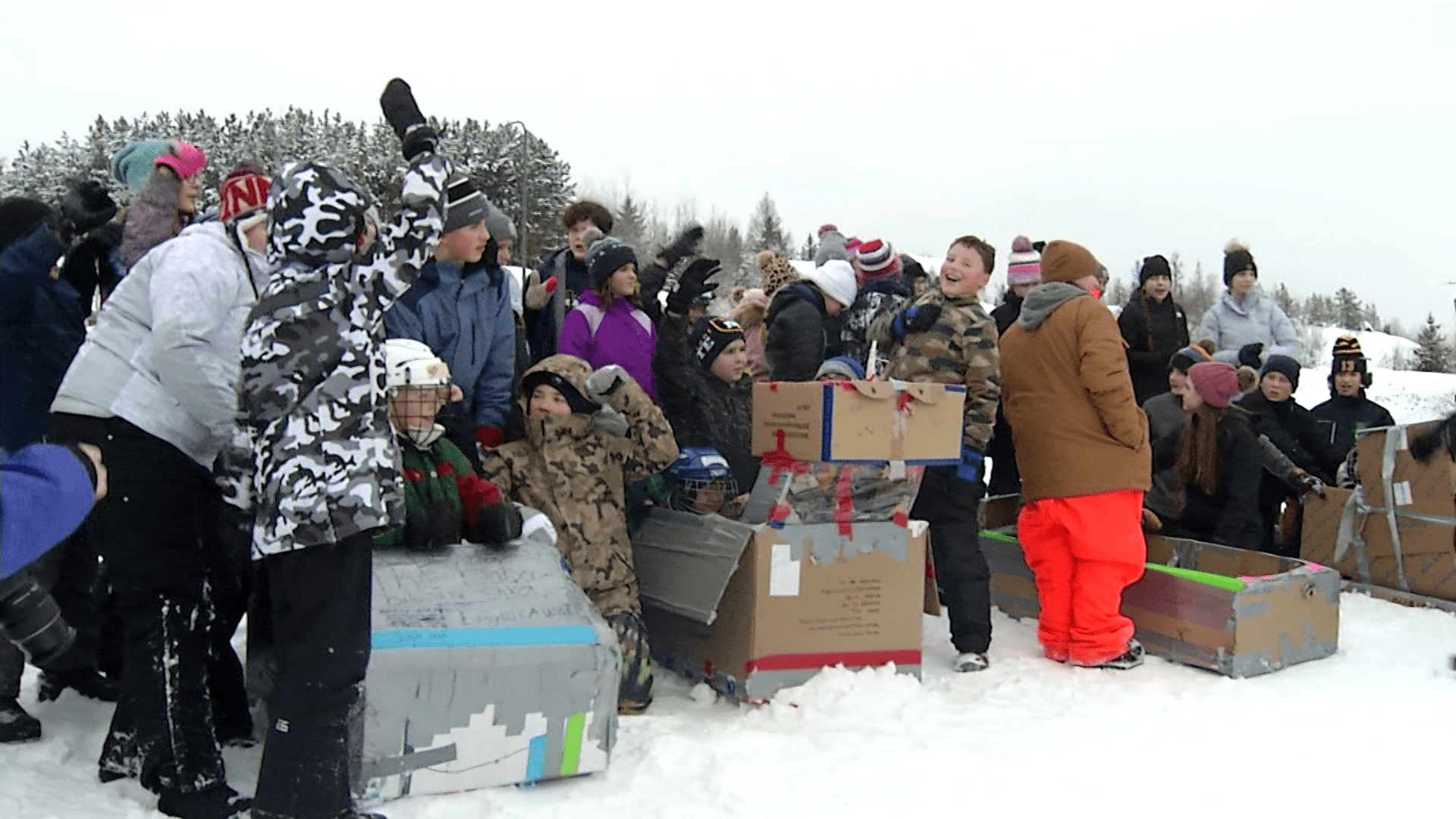 Students racing in cardboard-built sleds.