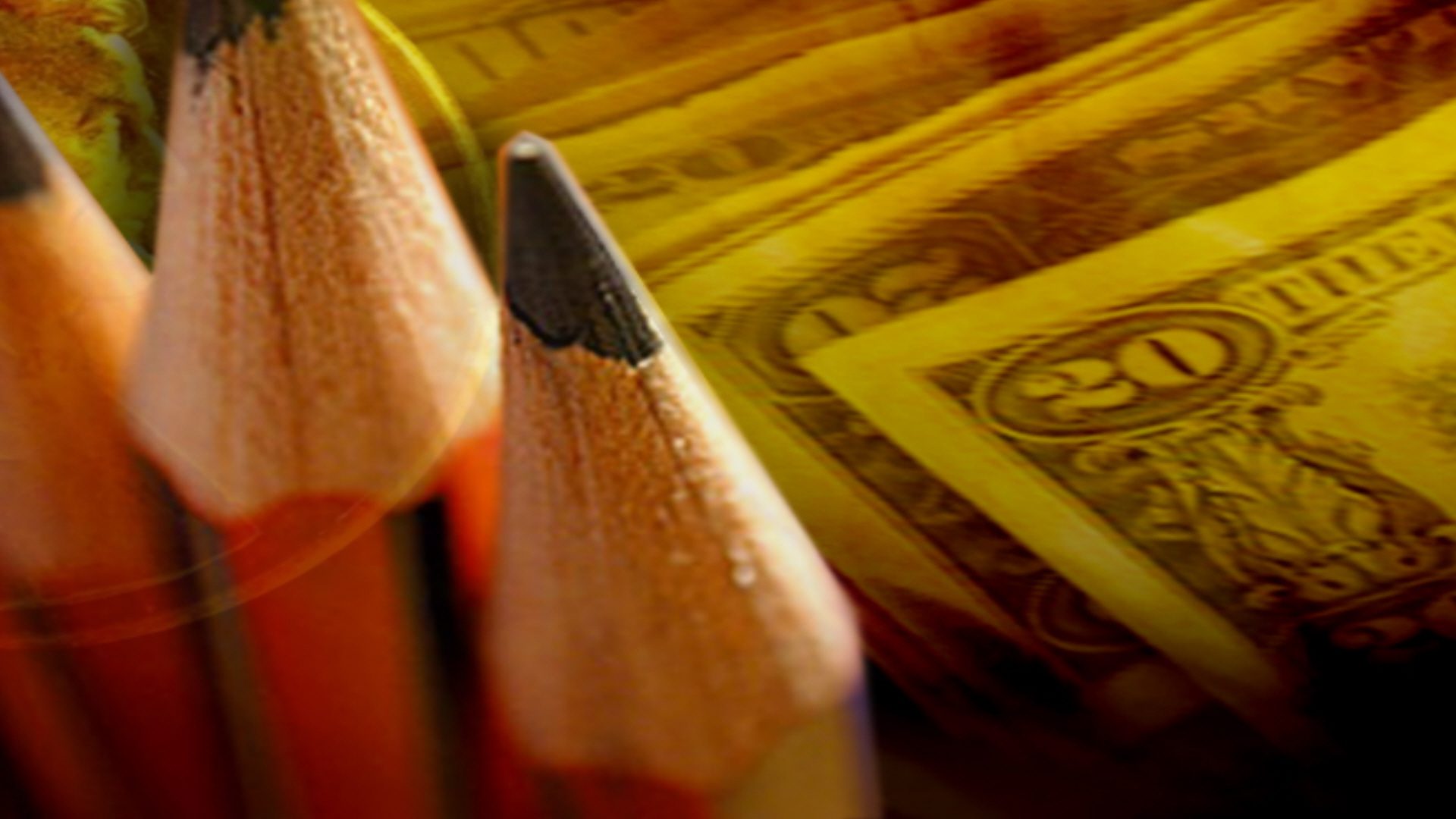 Money with pencils in the foreground.