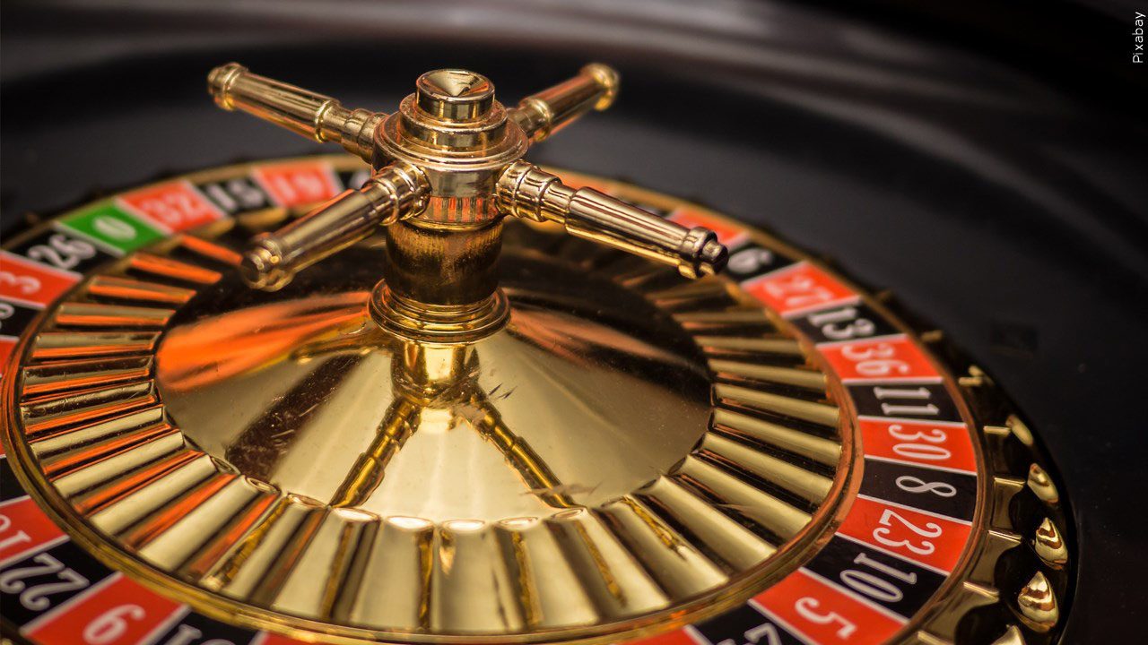 picture of a Roulette wheel on the left side with gold red and black.