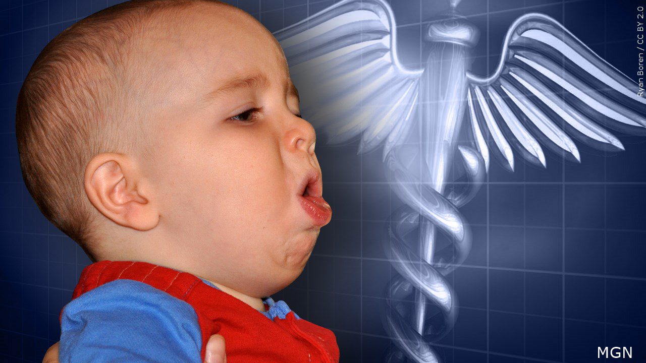 baby with whooping cough, medical symbol in the background