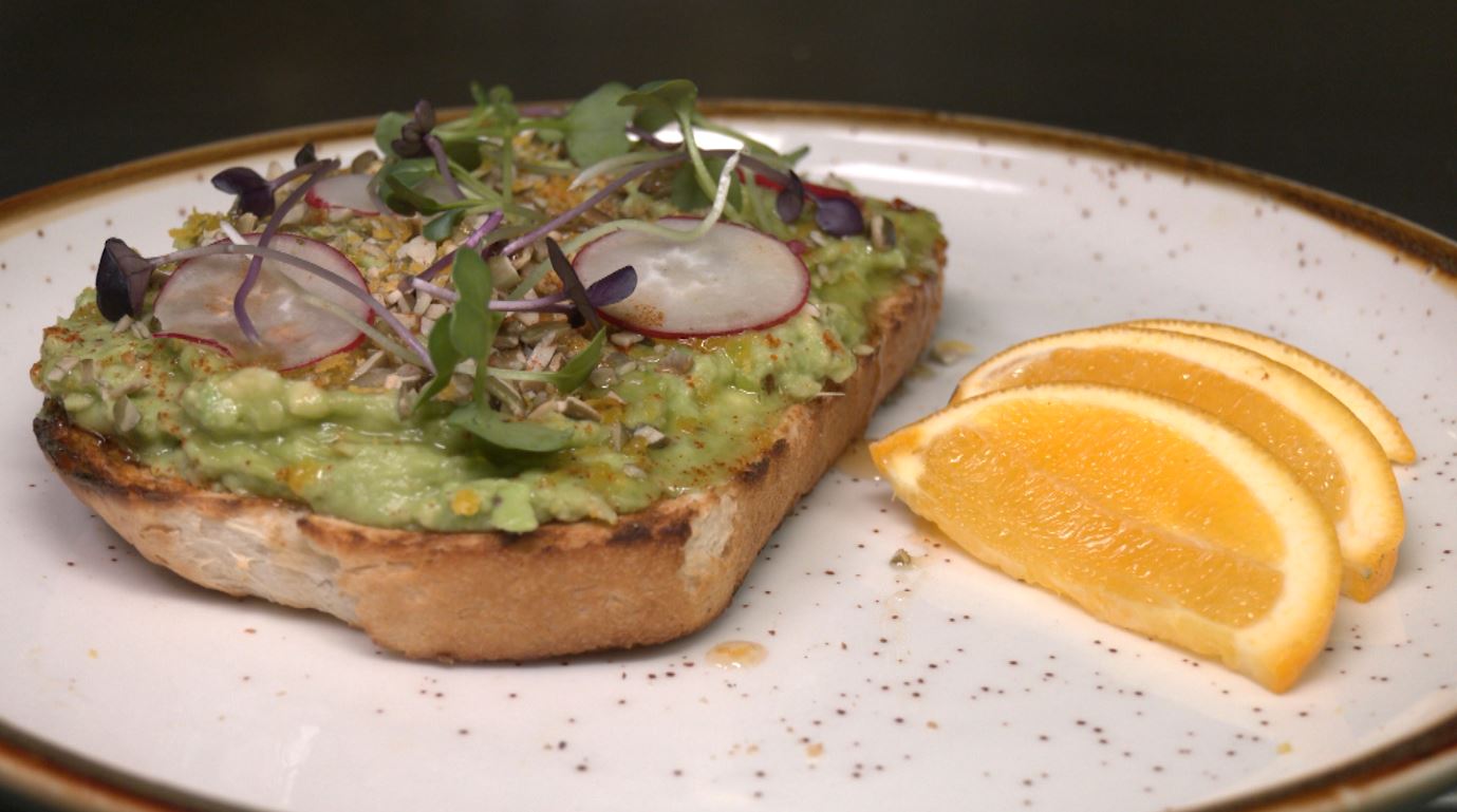 Avocado toast and orange slices on a plate