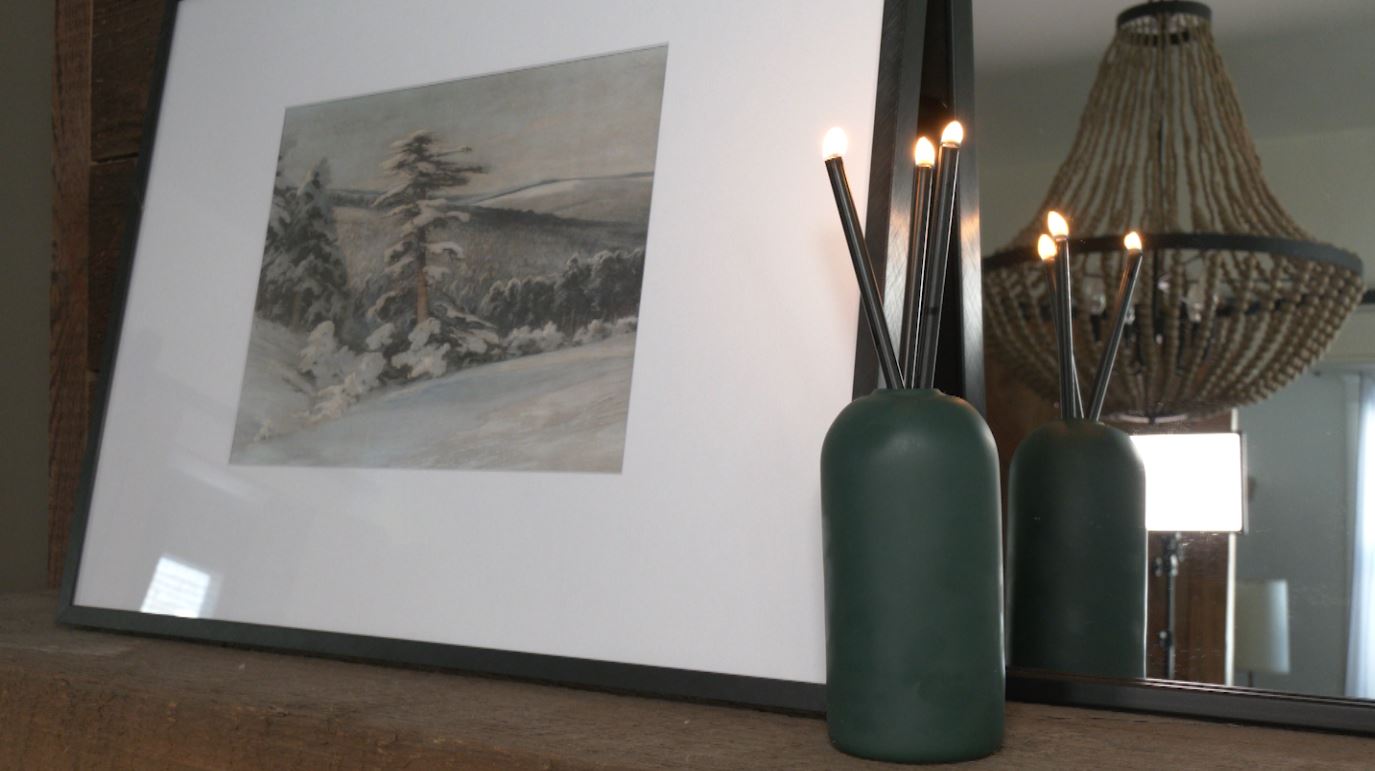 A candle sits next to an art piece