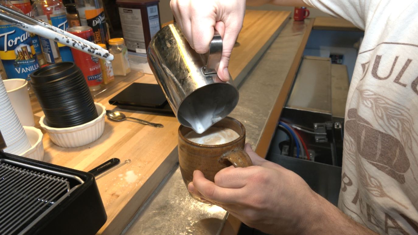 Robert Lillegard pours steamed milk into the Duluth Latte.