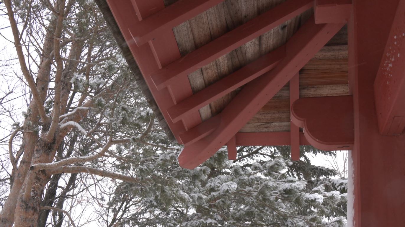 Snow falls outside the roof protecting the Japanese Peace Bell