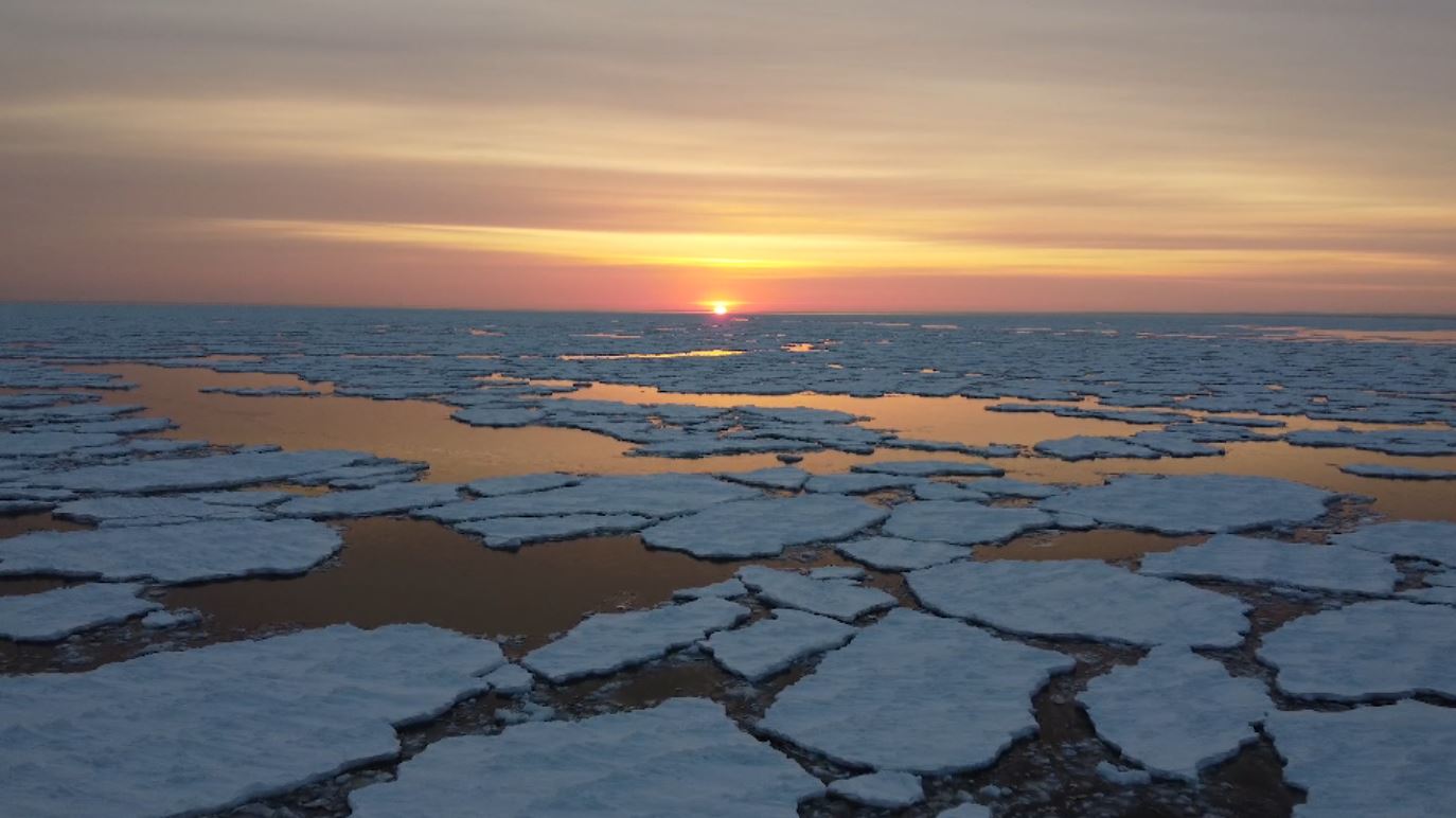 The sun rises over patches of ice on Lake Superior