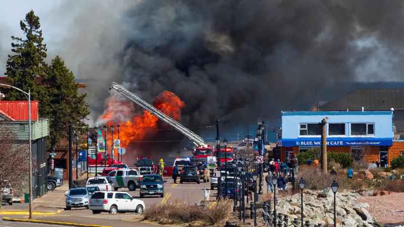 Flames, black smoke and a ladder fire truck can be seen at the Crooked Spoon Cafe in Grand Marais.