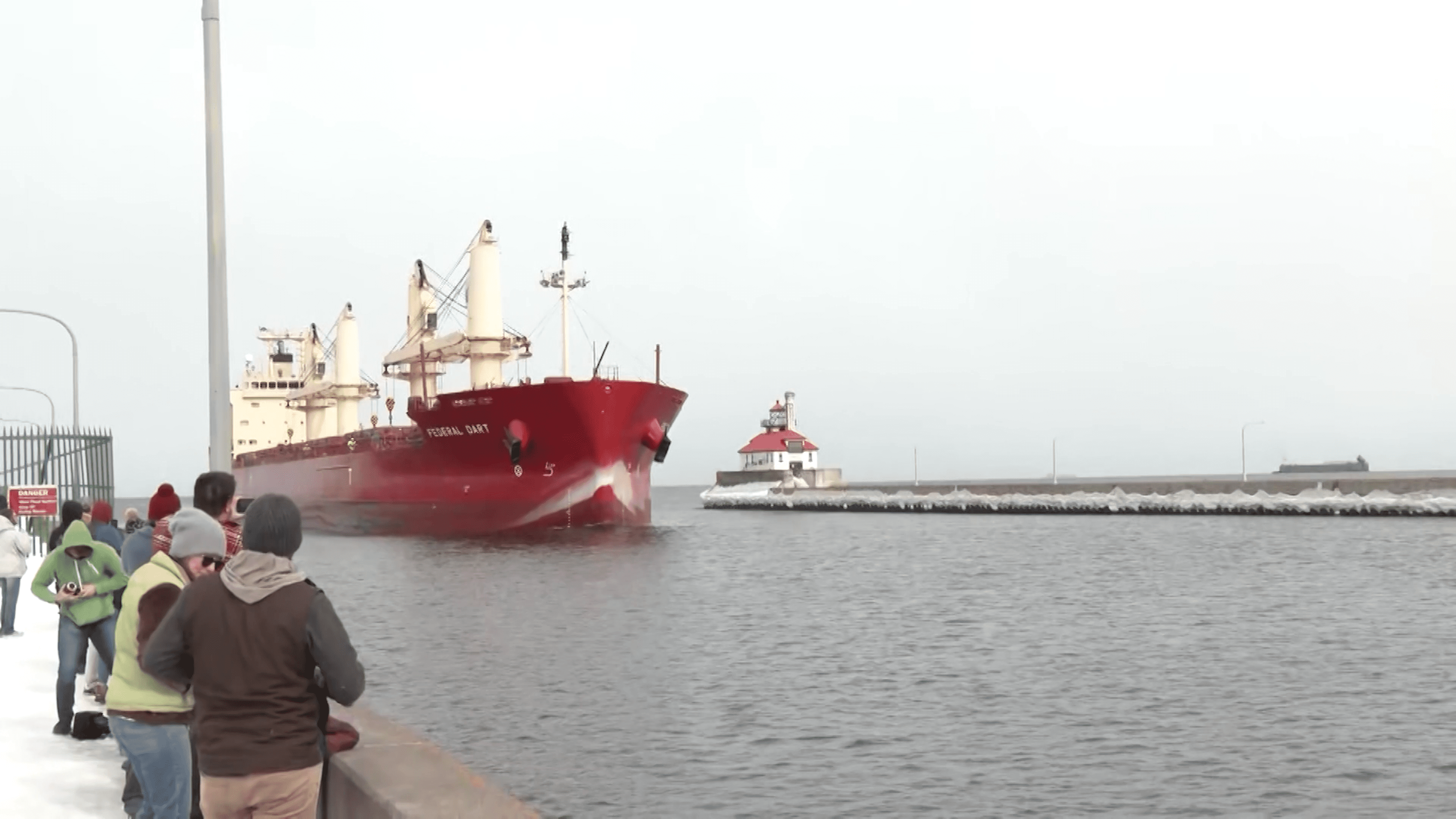 Red saltie ship, the Federal Dart is greeted by onlookers at the Duluth Canal.