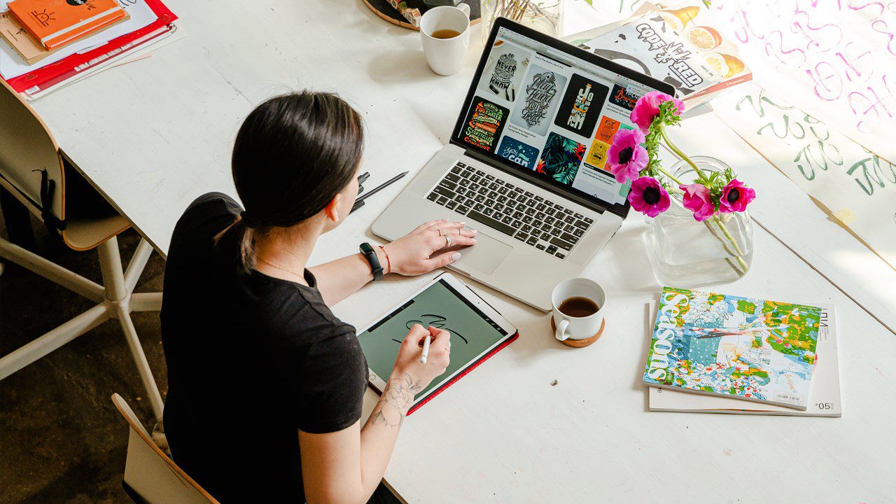 A woman works on a laptop at a desk