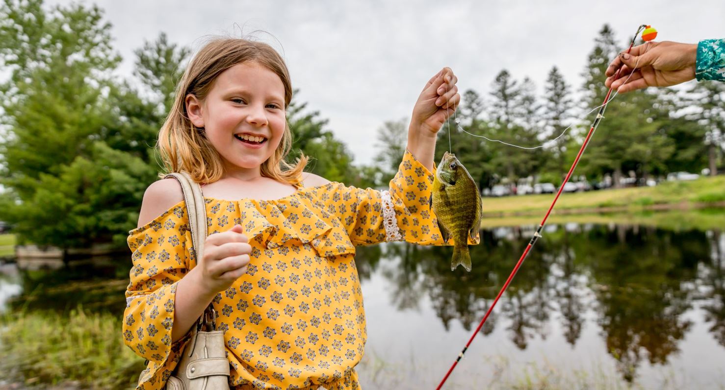 A girl holds a small fish