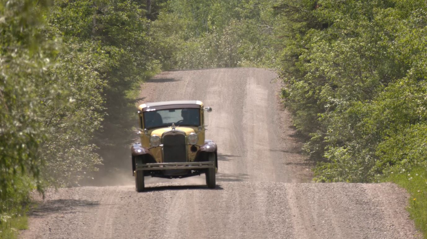 The Ford Model A driving down a dirt road
