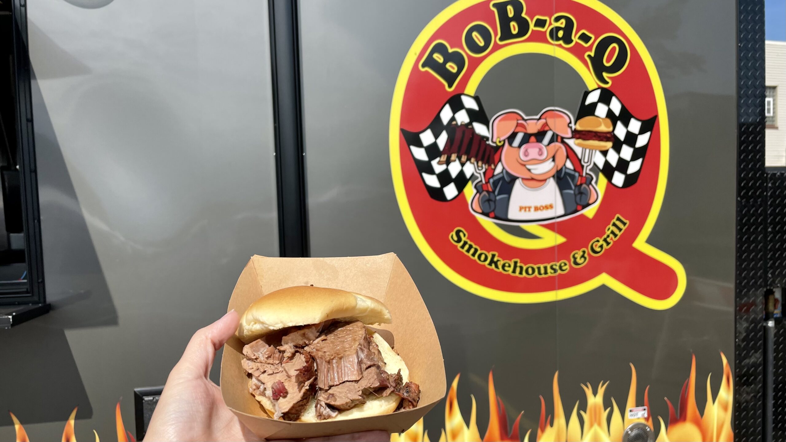 A brisket sandwich in front of the Bob-A-Q food truck