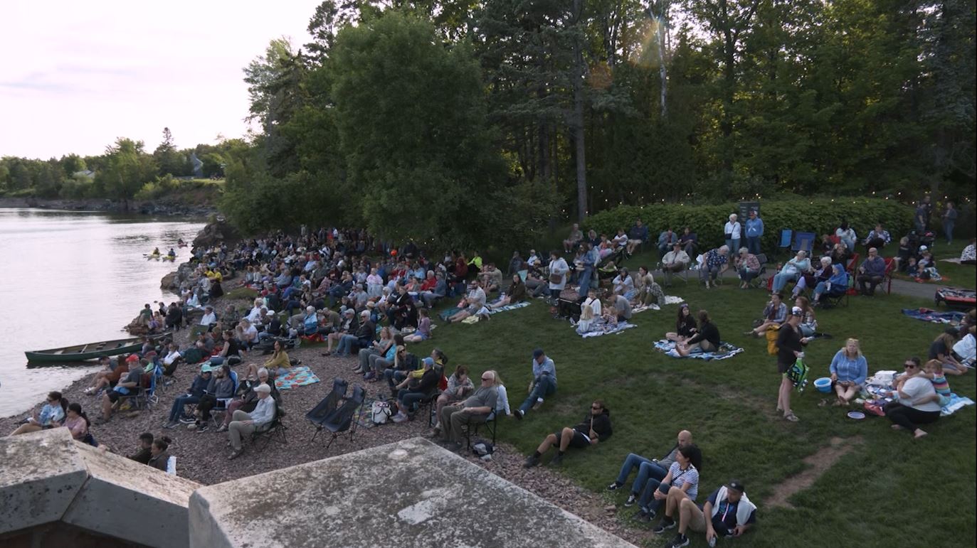 People listen to music on the grounds of the Glensheen Mansion.