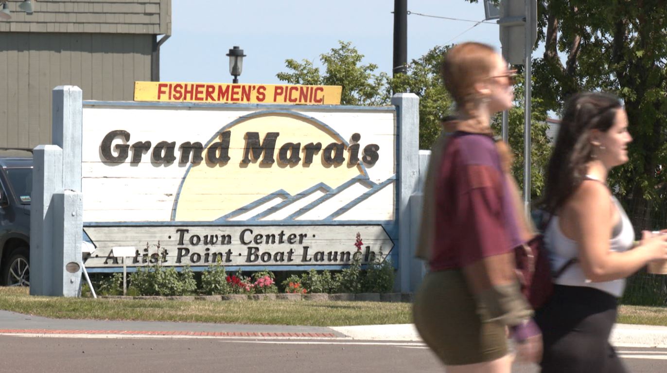 The Grand Marais sign with a Fishermen's Picnic banner