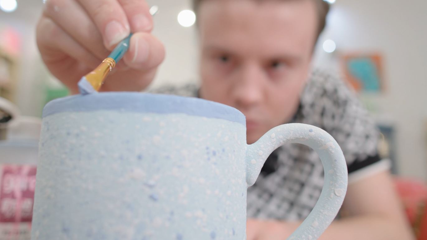 Kenny Johnson paints a coffee mug