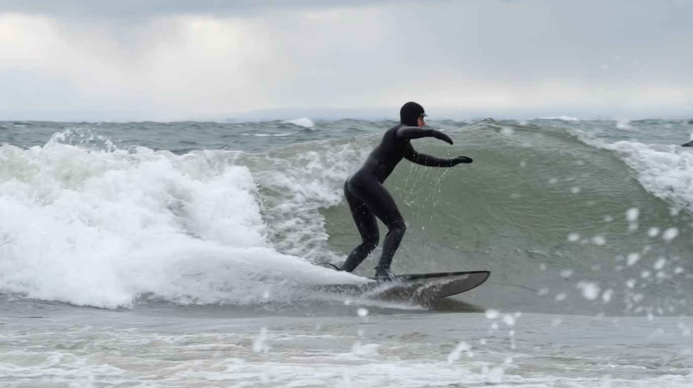 A surfer rides a wave on Lake Superior