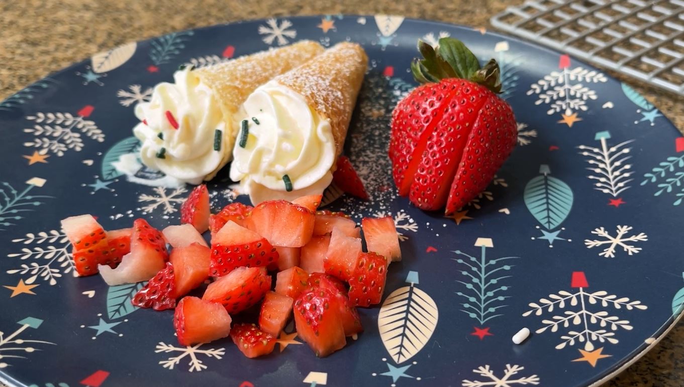 Krumkake cookies filled with whipped cream and served with chopped strawberries