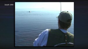 A man reels in a big fish on the shores of Lake Superior